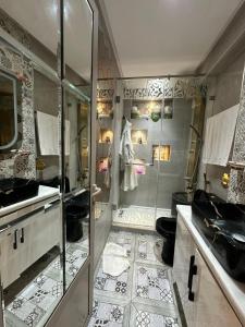 a bathroom with a shower and a toilet and a sink at Très Bel Appartement familial sur Rabat Temara PLAGES avec Piscines in El Harhoura