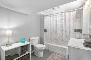 a white bathroom with a toilet and a shower at Classic Majesty in S MPLS in Minneapolis +27 photos