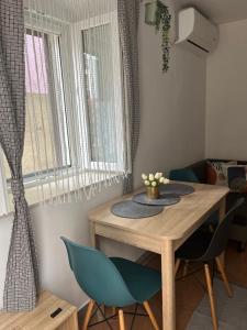 a dining room table with two blue chairs and a window at Apartment Nona in Cres
