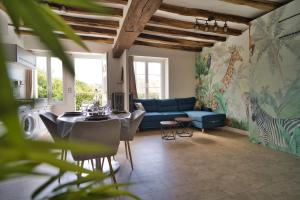 a living room with a blue couch and a table at Le Toucan in Saint-Aignan