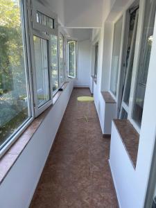 ein Flur mit Fenstern und einem gelben Tisch auf dem Boden in der Unterkunft Varna city Park Apartament in Warna