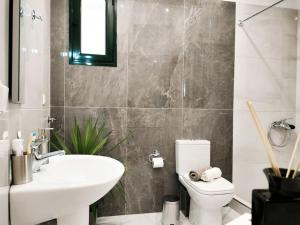 a bathroom with a white sink and a toilet at Classy Louvis House in Akti Salonikiou
