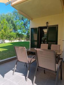 a patio with a table and chairs on a house at Classy Louvis House in Akti Salonikiou