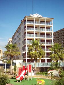 un parque infantil frente a un gran edificio en Primera Linea Villa Oropesa Magic World - Marina D'Or, en Oropesa del Mar