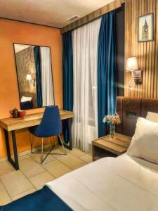 a hotel room with a bed and a desk and a mirror at Nani City Hotel in Zürich