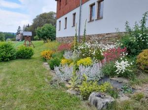 a garden of flowers in front of a building at Apartmán Matylda in Jáchymov