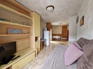 a living room with a couch and a kitchen at Apartament in the CENTER in Sauze dʼOulx
