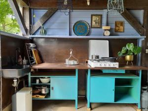 a kitchen with a blue desk and a sink at Het binnenerf yurt en keetjes in Nieuwleusen