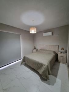 a white bedroom with a bed and a lamp at Ayres de Ana in Miramar +12 photos