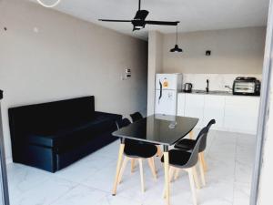 a black table and chairs in a kitchen with a black couch at Ayres de Ana in Miramar