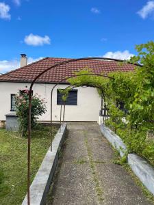 una casa con un arco di fronte di Maison proche Clermont-Fd entre CHU et Cézeaux -Parking a Beaumont