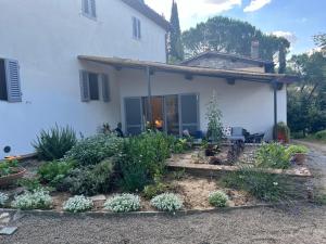 a garden in front of a white house at Joy home in Antella