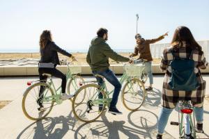 a group of people riding bikes on a sidewalk at Hotel Trieste Mare in Lignano Sabbiadoro