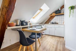 a kitchen with a wooden table and two chairs at Le Petit Refuge - nature & calme - parking in Le Meux