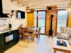 una cucina e un soggiorno con tavolo e sedie di Domek na Kaszubach 41-1 - Ostoja Bukowo a Borowy Młyn Altre 3 foto