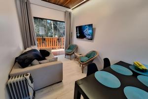 a living room with a couch and a table at Chalé Dália - Recanto Veky in Campos do Jordão