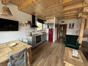 a kitchen with a table and a kitchen with a red refrigerator at Domek na Kaszubach 45-2 - Ostoja Bukowo in Borowy Młyn