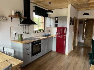 a kitchen with a red refrigerator and wooden floors at Domek na Kaszubach 45-2 - Ostoja Bukowo in Borowy Młyn +4 photos