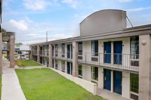 an exterior view of an apartment building with blue doors at Motel 6 Chickasha, OK in Chickasha