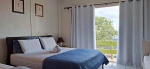 a bedroom with a bed with a doll sitting on it at Simar Hotel in Araranguá