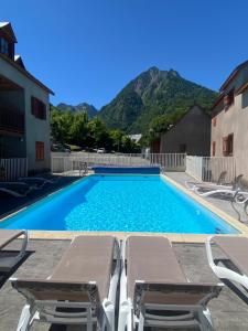 een zwembad met ligstoelen en een zwembad bij Joli duplex pr 5p, parking, balcon, piscine été in Cauterets