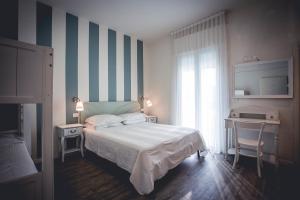 una camera con letto, scrivania e finestra di Hotel Ronchi a Cervia