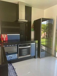 a kitchen with a stove and a microwave at Faith Home 1 in Arraial do Cabo