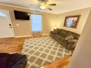 a living room with a couch and a television at Peaceful Townhouse Near Lake in Guntersville
