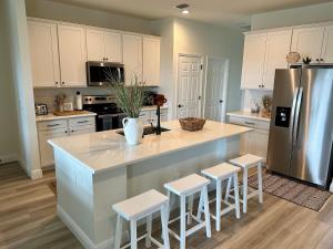 a kitchen with a island with stools and a refrigerator at Cape Coral-Ft Myers Waterfront Four Bedroom Home in Cape Coral