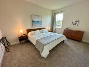 a bedroom with a bed and two night stands and a window at Cape Coral-Ft Myers Waterfront Four Bedroom Home in Cape Coral