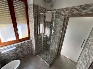 a shower with a glass door in a bathroom at TikiRoom in Lamezia Terme +1 photo