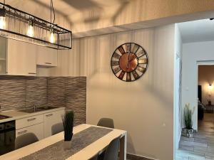 a kitchen with a table and a clock on the wall at Apartment Potocnica 222a in Novalja +23 photos