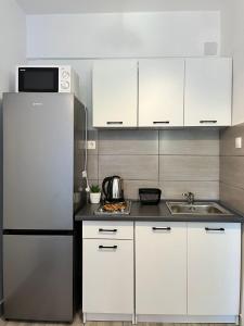 a kitchen with white cabinets and a refrigerator at Apartments by the sea Potocnica, Pag - 222 in Novalja +41 photos