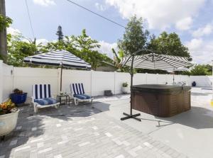 a patio with two chairs and two umbrellas at Mathel and Mar in West Palm Beach
