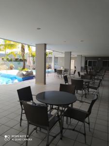 una cafetería con mesas y sillas y una piscina en Serra Park Reservas, en Rio Quente