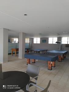 Habitación grande con 2 mesas de ping pong y sillas. en Serra Park Reservas, en Rio Quente