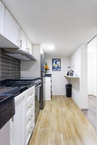 a kitchen with white cabinets and a wooden floor at Private Room #2 in a 4 bedroom Guest House in Roma Norte, Mexico City in Mexico City