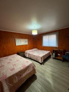 バルディビアにあるDepto Interior Eckhardt IIのベッドが2つと窓があるホテルの部屋