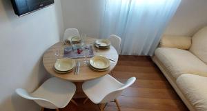 a wooden table with white chairs and a table and a couch at Apartments with parking space Kornic, Krk - 15293 in Kornić