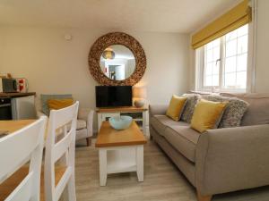 ein Wohnzimmer mit Sofa und Tisch in der Unterkunft Swallow Cottage in Ilfracombe