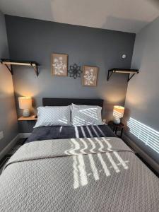 a bedroom with a large bed with two lights on it at Green Roof House Studio in Lakeland