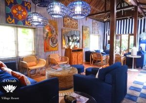 a living room with blue couches and chairs and lights at D'omah Yogya Hotel in Yogyakarta