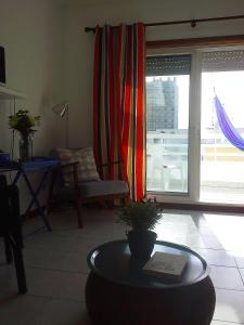 a living room with a table in front of a window at Charming with Sea View in Monte Gordo