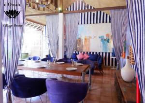 a dining room with a table and blue chairs at D'omah Yogya Hotel in Yogyakarta