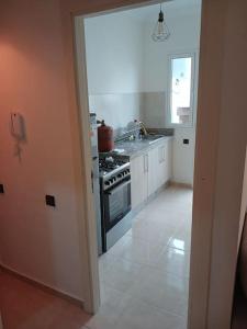a white kitchen with a stove and a sink at Appartement Cœur de Khouribga in Khouribga