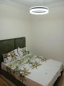 a bedroom with a bed with a green headboard at Appartement Cœur de Khouribga in Khouribga