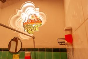 a bathroom with a chandelier on the wall at Tzunun Hostel in Antigua Guatemala