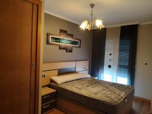 カマリーニャスにあるApartamento O Pesquiñoのシャンデリア付きの客室の小さなベッド1台分です。