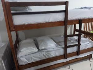 a couple of bunk beds with white pillows on them at Kitnet in Campo Grande +14 photos