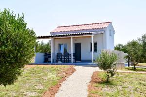 a small white house with a pathway leading to it at Seaside holiday house Cove Krlic, Pag - 23435 in Novalja